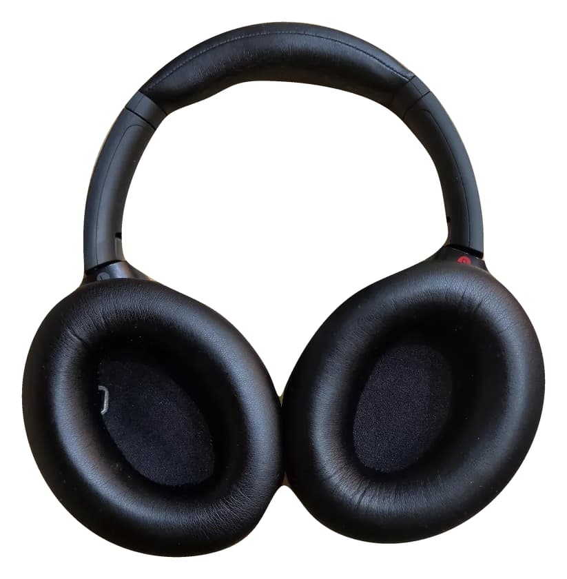 Black Sony WH-1000XM4 headphones isolated on white, showing the complete headband, ear cushions and inner earcup fabric.
